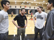 Brad Butterworth, a 39-year-old from Camas, talks with teammates on the Portland Bible College basketball team, Keoni Peneueta, left, Willie Bratcher, and Kenese Peneueta.