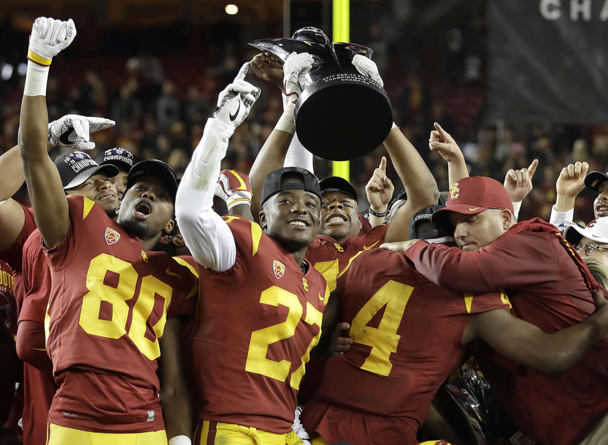 Southern California coach Clay Helton, right, celebrates with players after a 31-28 win over Stanford in the Pac-12 Conference championship NCAA college football game in Santa Clara, Calif., Friday, Dec. 1, 2017.