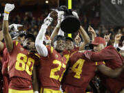 Southern California coach Clay Helton, right, celebrates with players after a 31-28 win over Stanford in the Pac-12 Conference championship NCAA college football game in Santa Clara, Calif., Friday, Dec. 1, 2017.