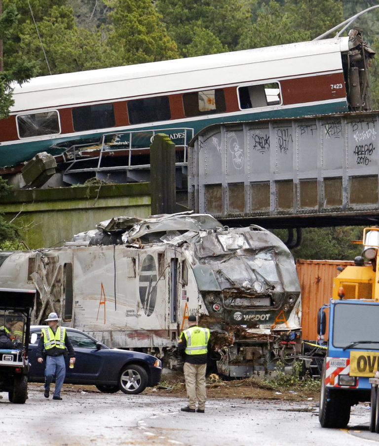 Cars from an Amtrak train lay spilled onto Interstate 5 below as some train cars remain on the tracks above Monday, Dec. 18, 2017, in DuPont, Wash. The Amtrak train making the first-ever run along a faster new route hurtled off the overpass Monday near Tacoma and spilled some of its cars onto the highway below, killing some people, authorities said.