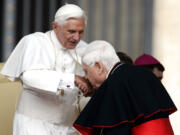 FILE - In this Wednesday June 7, 2006 file photo, Cardinal Bernard Law, right, kisses Pope Benedict XVI's hand at the end of the weekly general audience in St. Peter's Square at the Vatican. An official with the Catholic Church said Tuesday, Dec. 19, 2017, that Cardinal Bernard Law, the disgraced former archbishop of Boston, has died at 86. Law recently had been hospitalized in Rome and died early Wednesday.