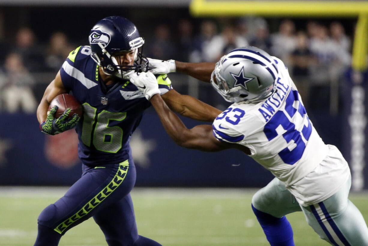 Seattle Seahawks receiver Tyler Lockett (16) has his face mask grabbed by Dallas Cowboys cornerback Chidobe Awuzie on Sunday in Arlington, Texas. Seattle won 21-12 to keep its playoff hopes alive.