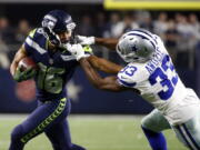 Seattle Seahawks receiver Tyler Lockett (16) has his face mask grabbed by Dallas Cowboys cornerback Chidobe Awuzie on Sunday in Arlington, Texas. Seattle won 21-12 to keep its playoff hopes alive.