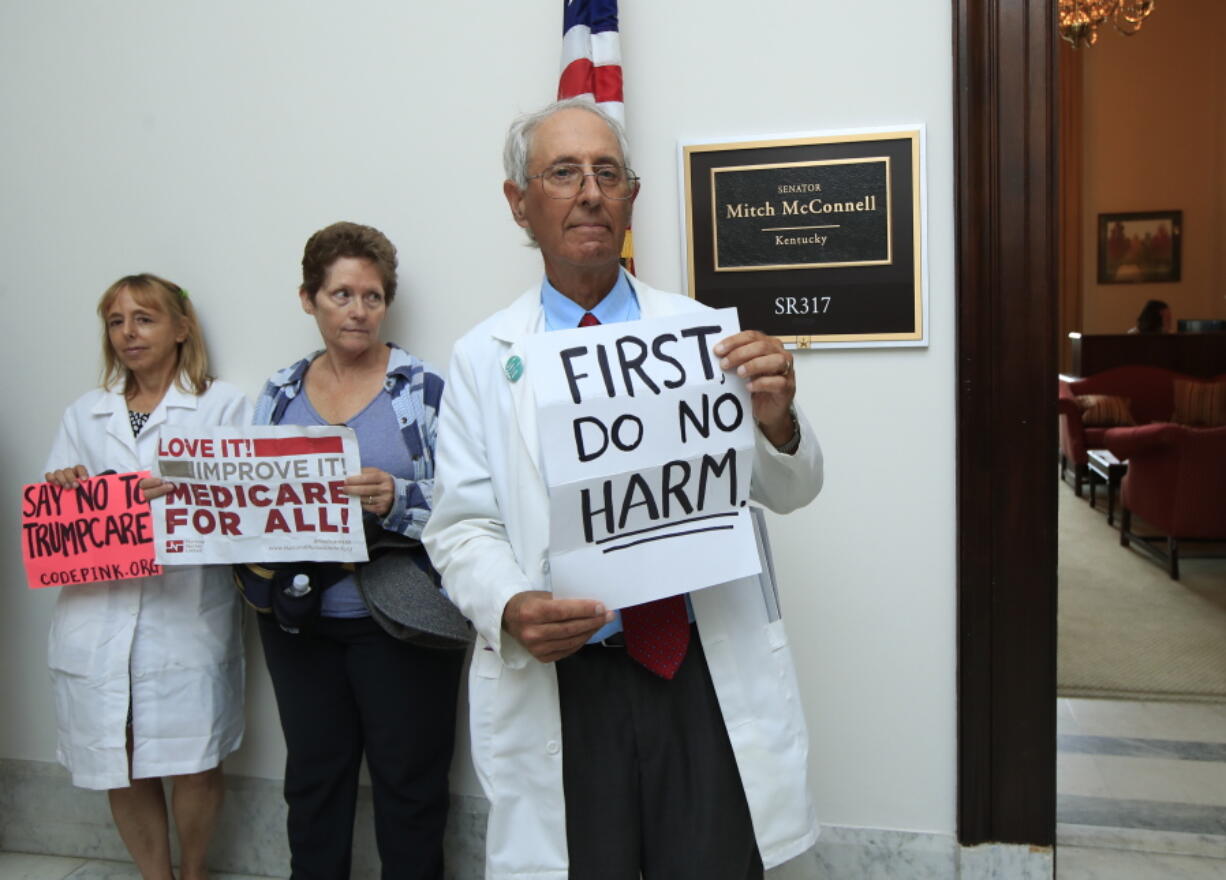 In this July 17, 2017 photo, retired family physician Jay Brock of Fredericksburg, Va., joins other protesters against the Republican health care bill outside the office of Senate Majority Leader Mitch McConnell of Ky., on Capitol Hill in Washington. A year after a big change in leadership, a survey by The Associated Press-NORC Center for Public Affairs Research finds that 48 percent named health care as a top problem for the country.