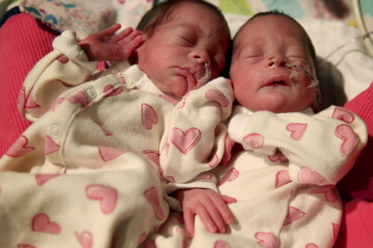 In this Dec. 11, 2017, photo, Aurora, left, and Phoenix Thompson Bailey, born Dec. 2, wear clothing made by inmates at the Coffee Creek Correctional Institute at the Salem Health Neonatal Intensive Care Unit in Salem, Ore. The twins are among the first babies to wear customized preemie clothing designed and manufactured inmates at the women’s prison in Wilsonville.