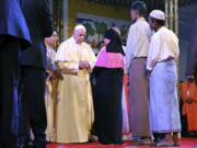 Pope Francis interacts with a Rohingya Muslim refugee at an interfaith peace meeting in Dhaka, Bangladesh, on Friday. Pope Francis ordained 16 priests during a Mass in Bangladesh on Friday, the start of a busy day that will bring him face-to-face with Rohingya Muslim refugees from Myanmar at an interreligious prayer for peace.