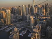 Two people ride the world's longest urban zip line with a speed of up to 80 kilometers per hour on a one kilometer run from 170 meter to ground level, at the Marina district of Dubai, United Arab Emirates, Tuesday, Dec. 5, 2017.