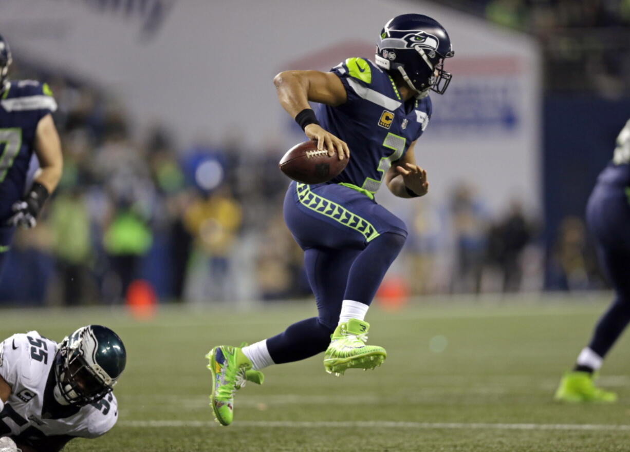 Seattle Seahawks quarterback Russell Wilson, right, leaps away from Philadelphia Eagles defender Brandon Graham in the second half of an NFL football game Sunday, Dec. 3, 2017, in Seattle. The Seahawks won 24-10.