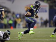 Seattle Seahawks quarterback Russell Wilson, right, leaps away from Philadelphia Eagles defender Brandon Graham in the second half of an NFL football game Sunday, Dec. 3, 2017, in Seattle. The Seahawks won 24-10.