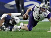 Washington quarterback Jake Browning (3) is tripped up by Penn State defensive end Shareef Miller (48) during the second half of the Fiesta Bowl NCAA college football game, Saturday, Dec. 30, 2017, in Glendale, Ariz.