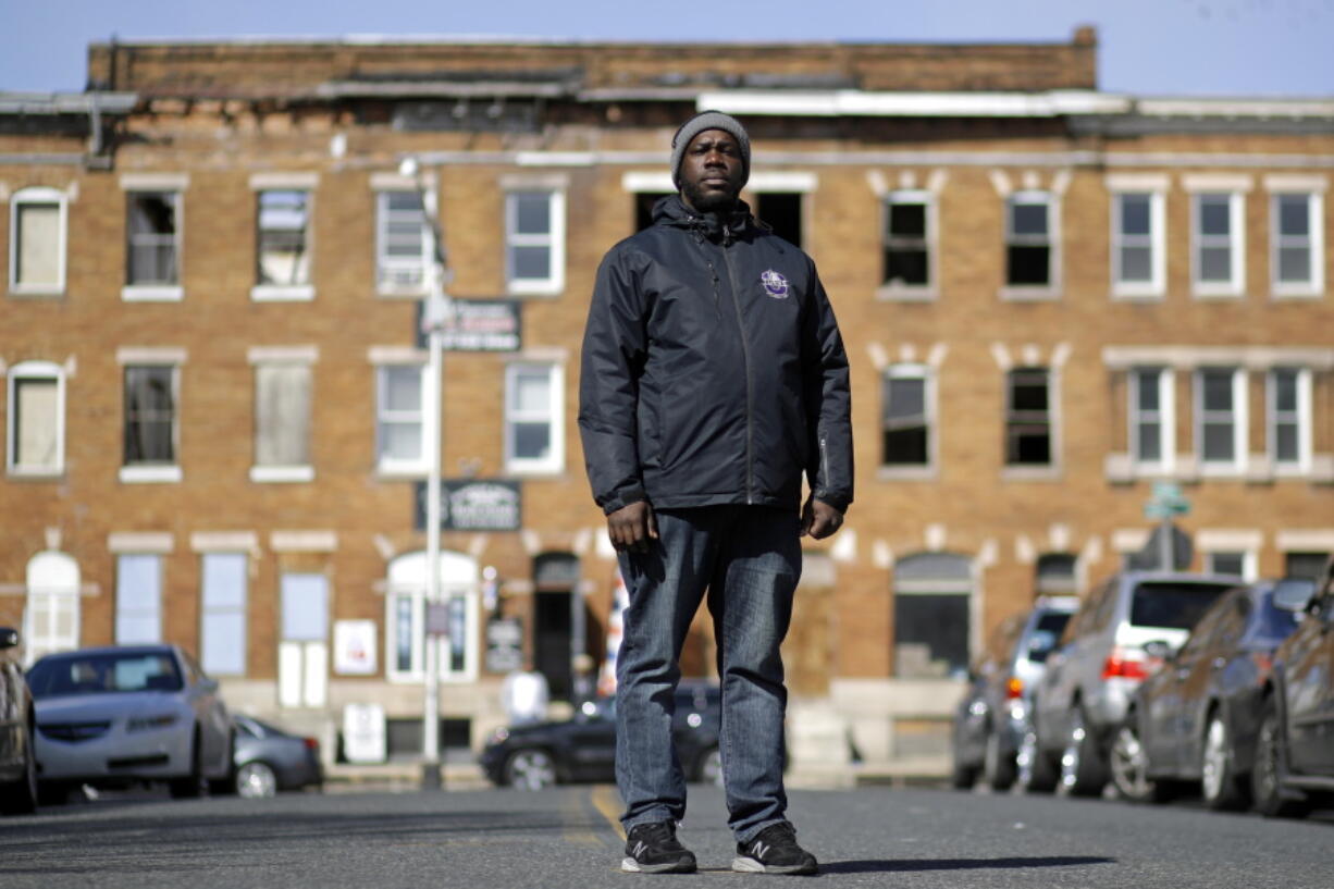 In this March 3, 2017 photo, community outreach worker Kelvin Parker poses for a portrait while walking in the Sandtown-Winchester neighborhood of Baltimore. Parker is one of three outreach workers at U-TURNS, a fledgling initiative with an ambitious goal: to reach teenagers and young adults in west Baltimore and provide an alternative to the streets.