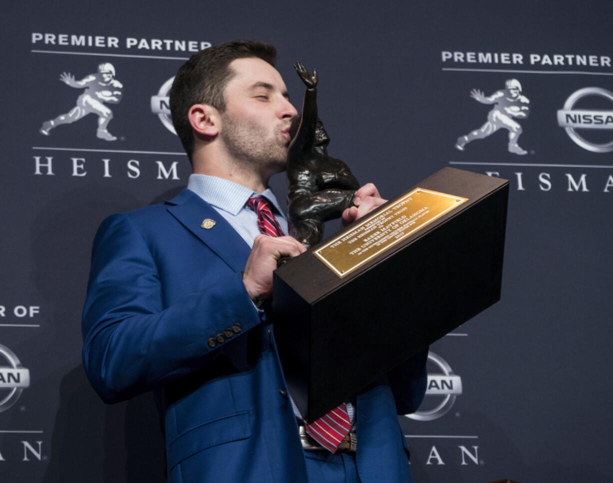 Oklahoma quarterback Baker Mayfield, winner of the Heisman Trophy, kisses the trophy Saturday, Dec. 9, 2017, in New York.