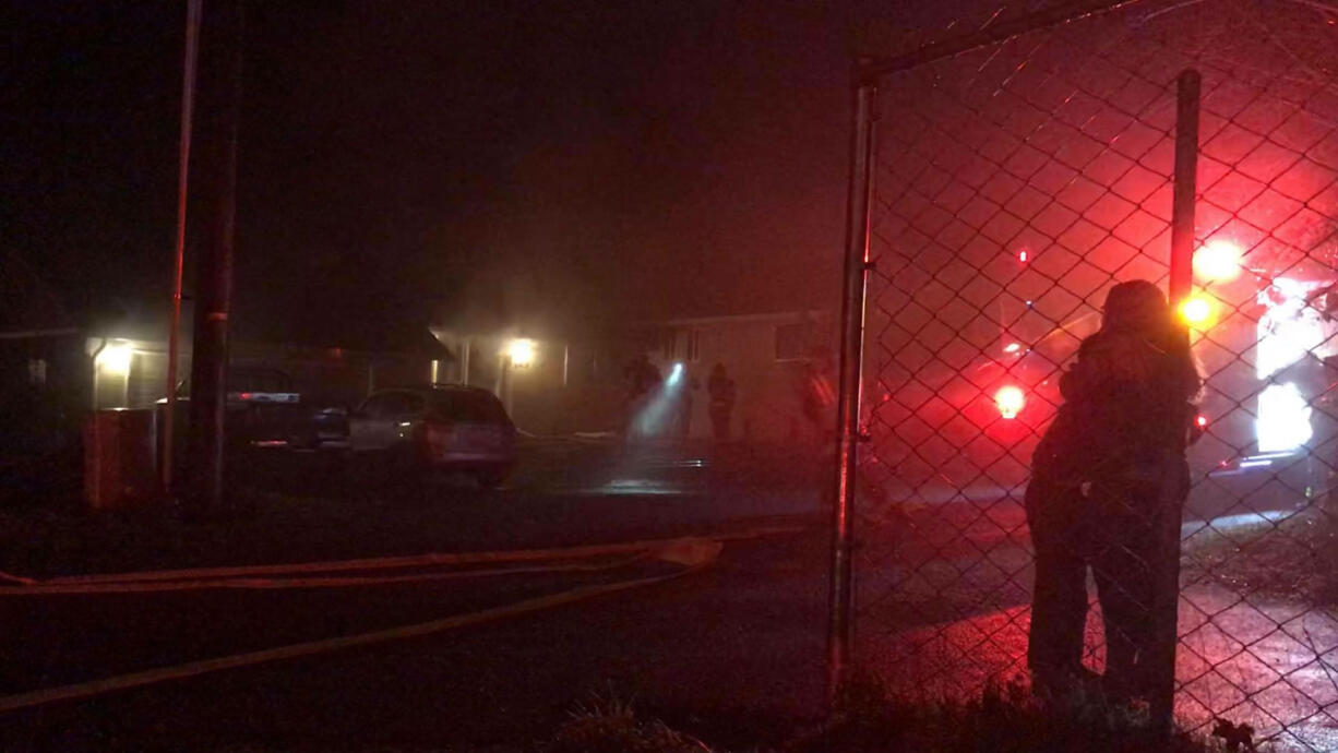 Family members embrace Wednesday night after fire damaged their home at 6402 N.E. 66th Ave., in Vancouver’s Walnut Grove neighborhood.