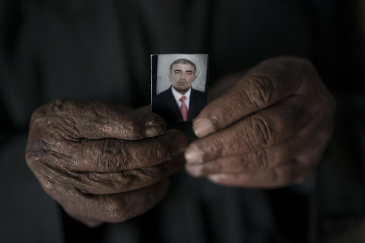 Ghanim Ahmed holds the photo of his son Ghazwan Ahmed, who was taken by unidentified gunmen after their village was liberated from Islamic State militants, in Bijwaniya village, south of Mosul, Iraq.