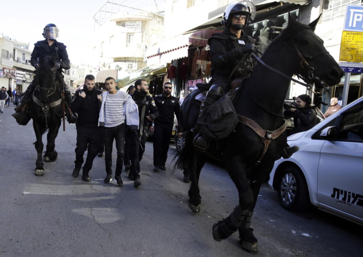 Israel police arrest a Palestinian during a protest against U.S.