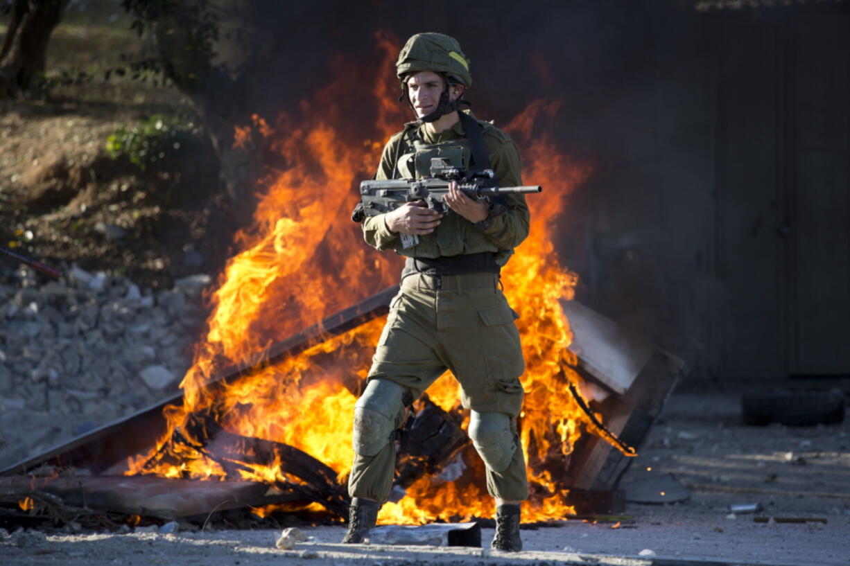 Israeli soldier stands during clashes with Palestinians following a protest against U.S. President Donald Trump’s decision to recognize Jerusalem as the capital of Israel in the West Bank City of Nablus, Friday, Dec. 8, 2017.