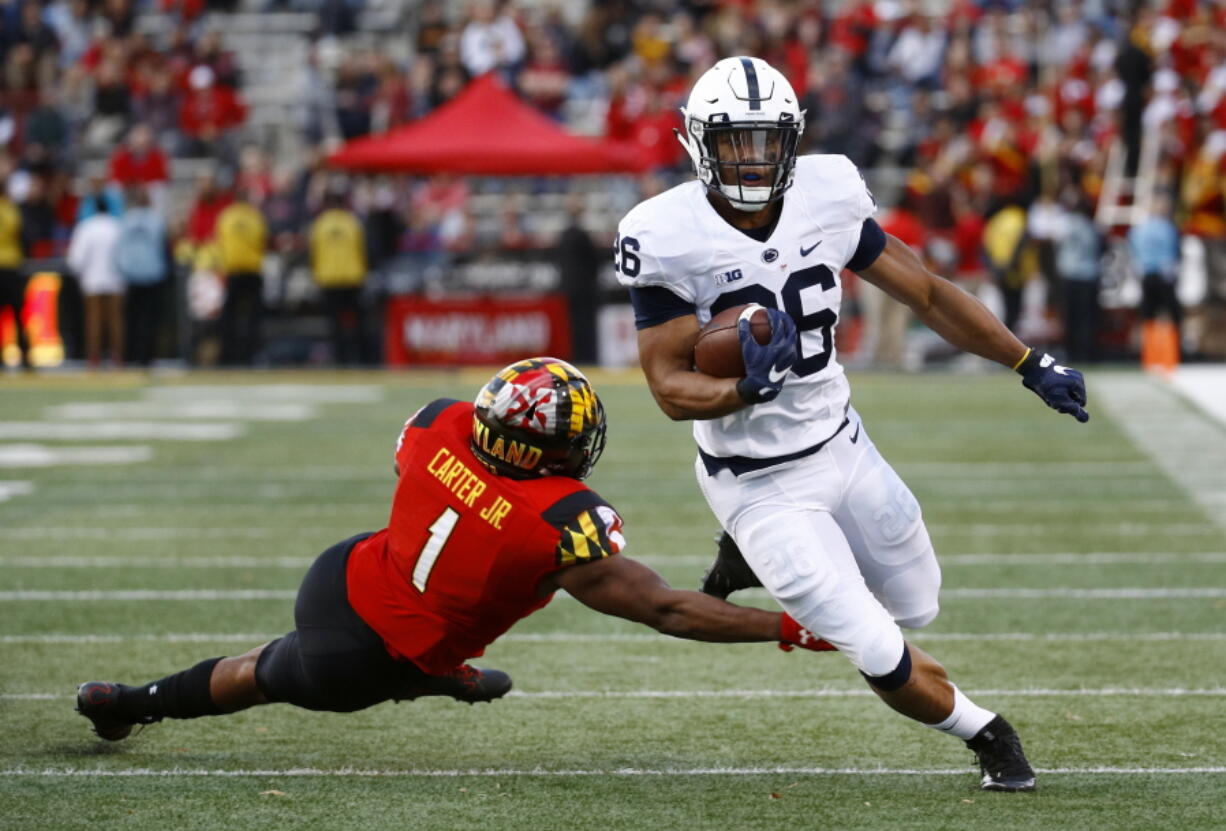 Penn State running back Saquon Barkley, right, rushes past Maryland linebacker Jermaine Carter Jr. in the first half of an NCAA college football game in College Park, Md., Saturday, Nov. 25, 2017.