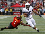 Penn State running back Saquon Barkley, right, rushes past Maryland linebacker Jermaine Carter Jr. in the first half of an NCAA college football game in College Park, Md., Saturday, Nov. 25, 2017.