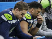 Seattle Seahawks quarterback Russell Wilson, right, and backup quarterback Austin Davis, left, sit on the bench during the second half Sunday’s 42-7 loss to the Los Angeles Rams. The Seahawks have dominated the NFC West and never missed the playoffs since drafting Wilson in 2012. Now Seattle will need two straight wins and likely help from others to reach the postseason.