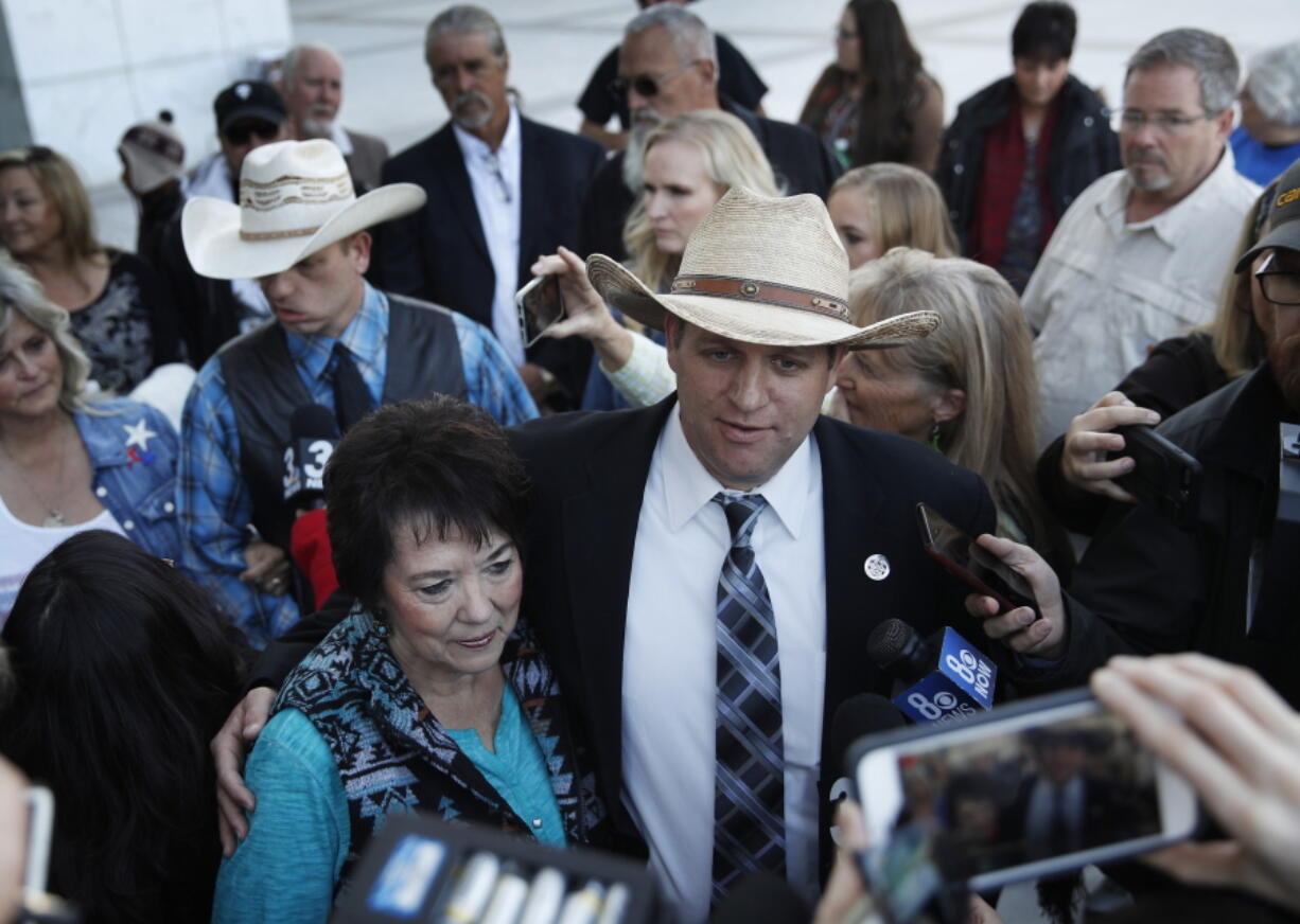 Ammon Bundy, right, and Carol Bundy, wife of Nevada rancher Cliven Bundy, speak with reporters outside of a federal courthouse Wednesday, Dec. 20, 2017, in Las Vegas. Chief U.S. District Judge Gloria Navarro declared a mistrial Wednesday in the case against Cliven Bundy, his sons Ryan and Ammon Bundy and self-styled Montana militia leader Ryan Payne.