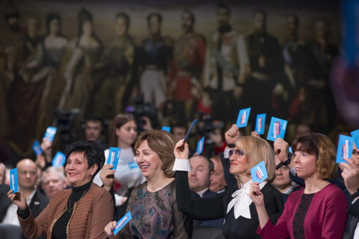 Supporters of incumbent Vladimir Putin vote to officially nominate him for presidency in Moscow, Russia, Tuesday, Dec. 26, 2017. Putin is set to easily win a fourth term in office in the March 18 election, with his approval ratings topping 80 percent.