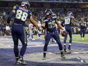 Seattle Seahawks’ Jimmy Graham (88) congratulates Doug Baldwin (89) on his touchdown catch in the second half of an NFL football game against the Dallas Cowboys on Sunday, Dec. 24, 2017, in Arlington, Texas.