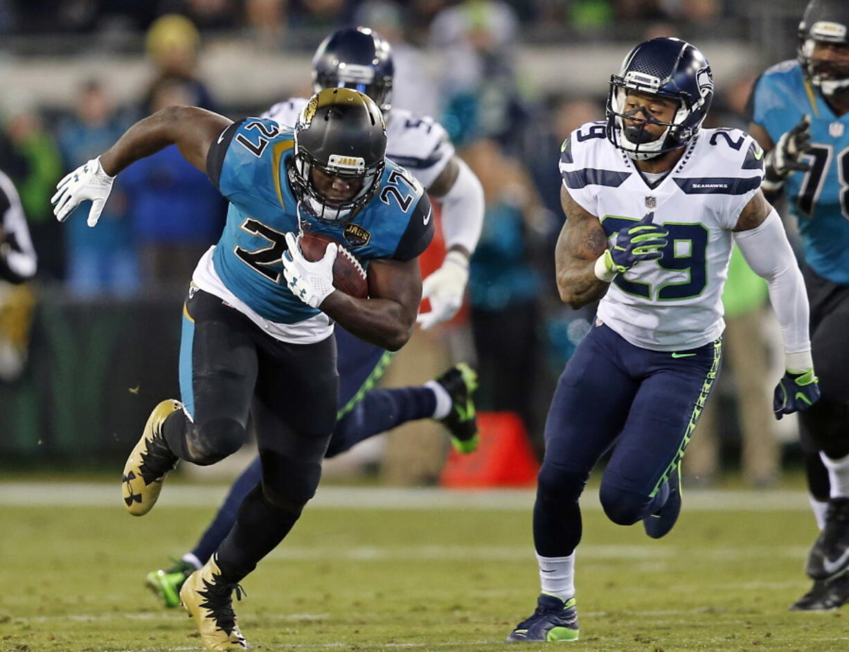 Jacksonville Jaguars running back Leonard Fournette (27) runs for yardage past Seattle Seahawks safety Earl Thomas (29) during the second half of an NFL football game, Sunday, Dec. 10, 2017, in Jacksonville, Fla. (AP Photo/Stephen B.