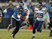 Jacksonville Jaguars running back Leonard Fournette (27) runs for yardage past Seattle Seahawks safety Earl Thomas (29) during the second half of an NFL football game, Sunday, Dec. 10, 2017, in Jacksonville, Fla. (AP Photo/Stephen B.