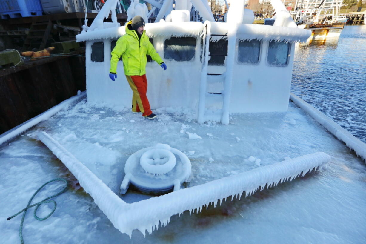 With temperatures in the single digits, Ray Levesque, mate of the crab/lobster boat Bradbill, makes his way across the deck covered in ice to tie off, after arriving in New Bedford, Mass., harbor on Thursday, Dec. 28, 2017, from a one day fishing voyage. Temperatures across Massachusetts are not expected to rise above freezing for days.