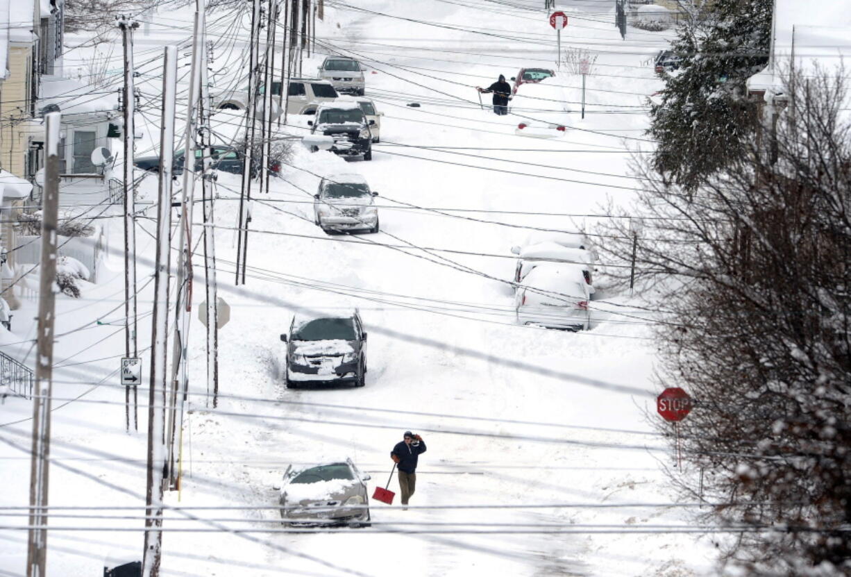 Erie, Pa., residents on East 24th Street dig out on Tuesday after a record two-day snowfall. The National Weather Service office in Cleveland says the storm brought 34 inches on Christmas Day, a new all-time daily snowfall record for Erie.