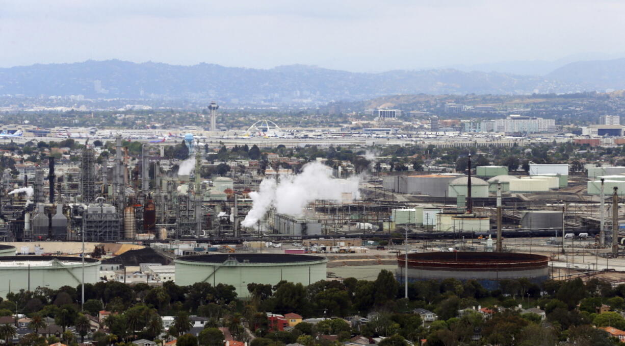 FILE - This May 25, 2017 aerial file photo shows the Standard Oil Refinery in El Segundo, Calif., with Los Angeles International Airport in the background and the El Porto neighborhood of Manhattan Beach, Calif., in the foreground. California Attorney General Xavier Becerra announced, Thursday, Dec. 7, 2017, that California is among fourteen states and the District of Columbia that are suing the Trump administration over what they say a failure to enforce smog standards.