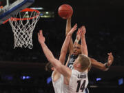 Villanova guard Mikal Bridges (25) dunks the ball against Gonzaga forward Killian Tillie, left, and center Jacob Larsen (14) during the second half of an NCAA college basketball game, Tuesday, Dec. 5, 2017, in New York. Villanova won 88-72.