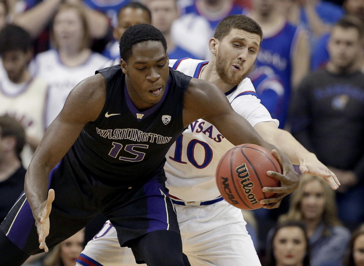 Kansas' Sviatoslav Mykhailiuk (10) tries to steal the ball from Washington's Noah Dickerson (15) during the first half of an NCAA college basketball game Wednesday, Dec. 6, 2017, in Kansas City, Mo.