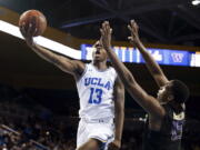 UCLA guard Kris Wilkes, left, goes to the basket while defended by Washington forward Noah Dickerson during the second half of an NCAA college basketball game in Los Angeles, Sunday, Dec. 31, 2017. UCLA won 74-53. (AP Photo/Ringo H.W.