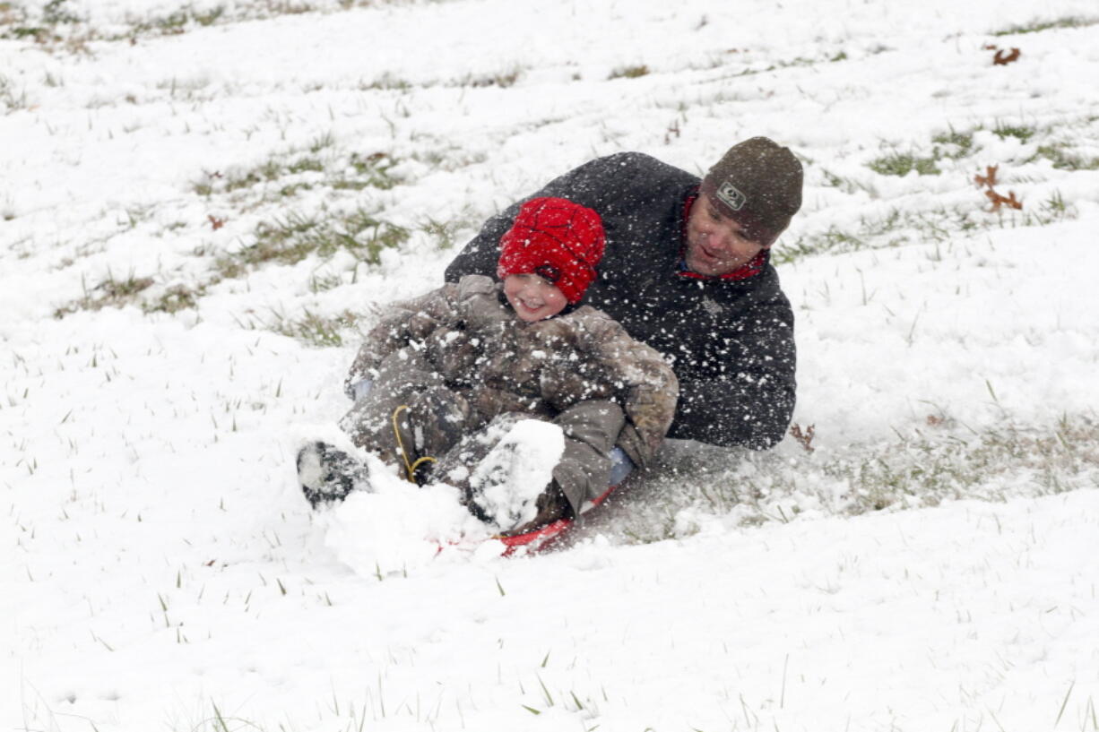 Allen and Cooper Alexander, 4, spin around while sledding down a hill Friday Dec. 8, 2017, in Vicksburg, Miss. Heavy snow fell across several Southern states Friday.