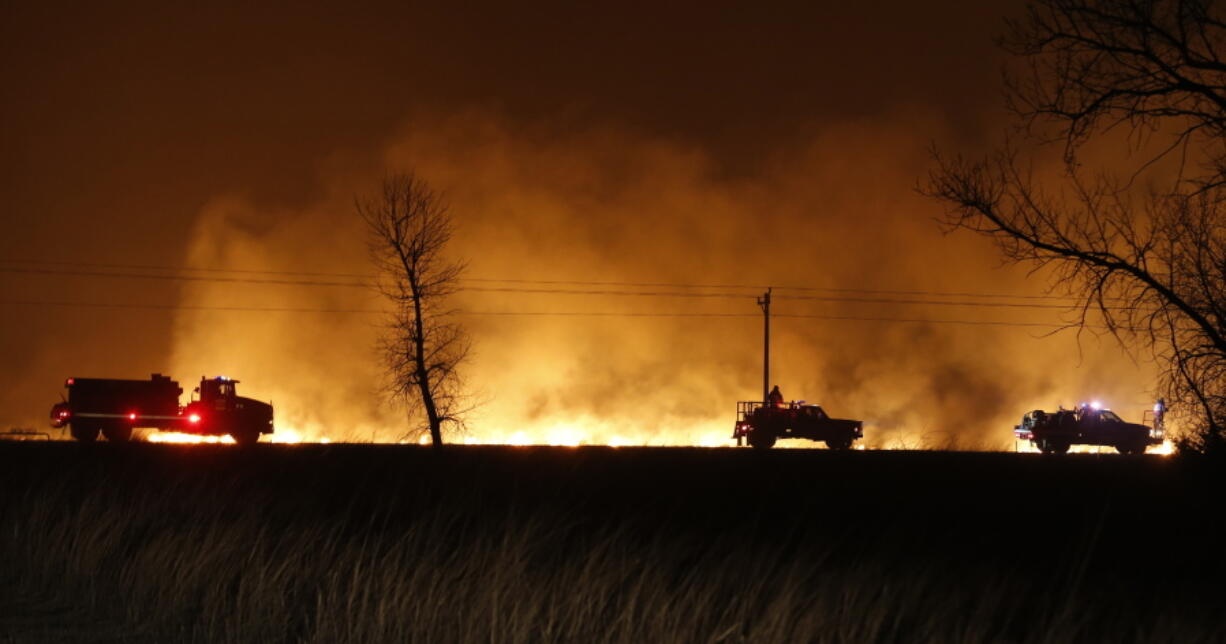 FILE - In this March 6, 2017 file photo, firefighters from across Kansas and Oklahoma battle a wildfire near Protection, Kan. The La Nina climate phenomenon in the south Pacific Ocean is contributing to weather conditions that are expected to be warm and dry with low humidity, leading to fears of a sharp increase in winter wildfires from the mid-South through the Great Plains.