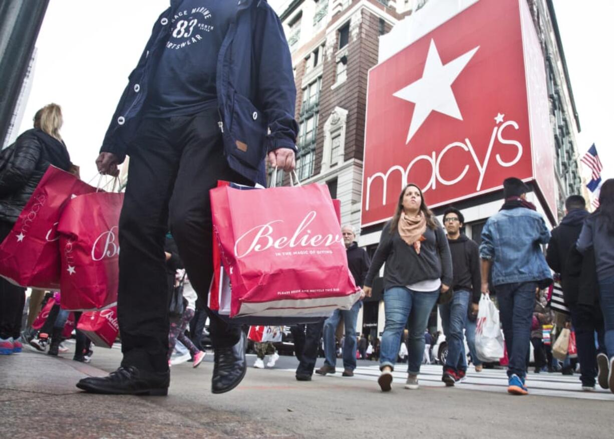 Shoppers carry bags as they cross a pedestrian walkway in November near Macy’s in Herald Square in New York.