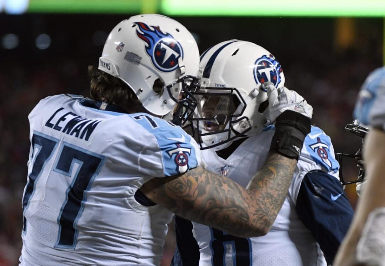 Tennessee Titans offensive tackle Taylor Lewan (77) congratulates quarterback Marcus Mariota (8) after he scored a touchdown against the Kansas City Chiefs during the second half of an NFL wild-card playoff football game, in Kansas City, Mo., Saturday, Jan. 6, 2018.