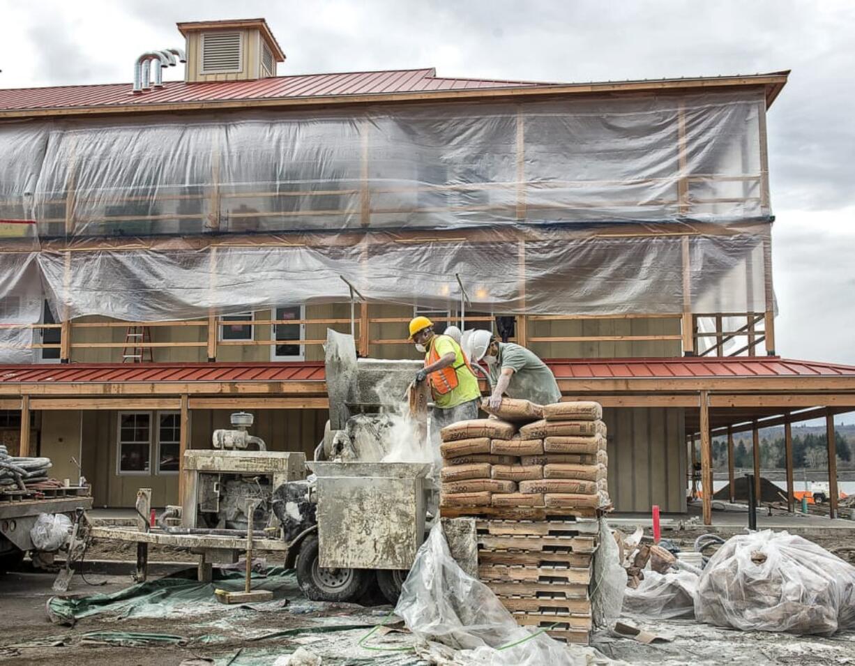 Workers mix batches of gypcrete to be pumped in to crews inside the Kalalma Harbor Lodge, where they spread it to make subflooring.