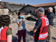 Ron Burby and another Red Cross volunteer speak with Michele and John Ward in the Skyline neighborhood of Ventura, Calif. Red Cross says the couple’s home was reduced to ash, but they plan to rebuild.