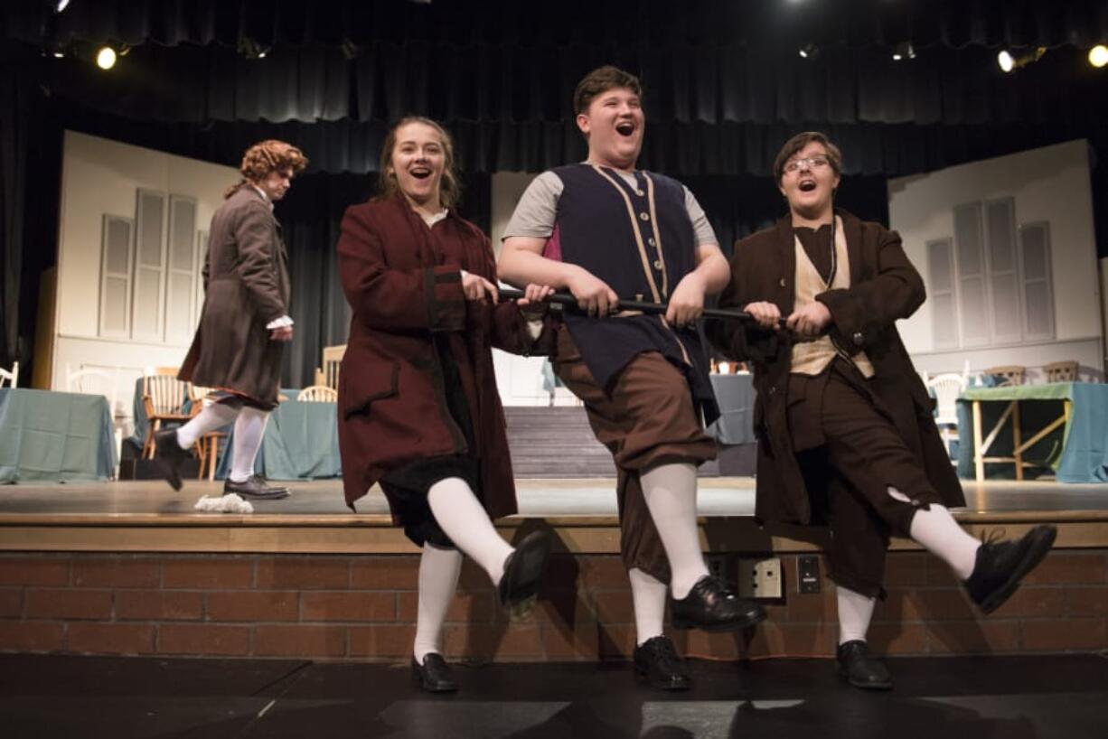 A colonial chorus line: Heritage High School junior Dakota Adams, left, senior Jordyn Fields, and sophomore Connor Randall step-kick their way to American independence in the musical “1776.” Alisha Jucevic/The Columbian