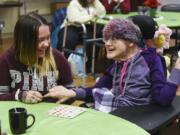 Megan Rugh, left, resource guide for The Arc of Southwest Washington, helps her client, Sondra Thompson, play bingo at the Luepke Center. Guides like Rugh help people stay engaged in the community.