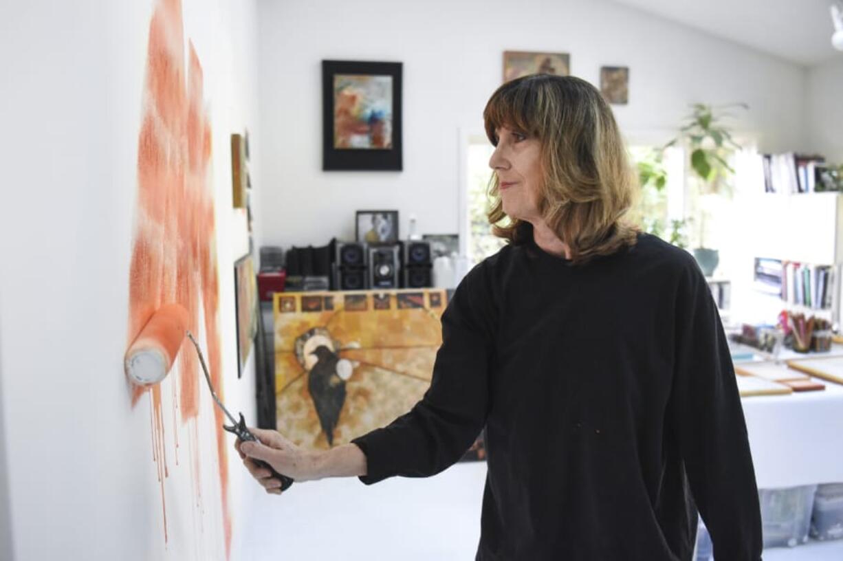 Painter Anne John starts layering background color onto a new canvas at her studio. She’s beginning a series of pieces inspired by photos she took of the smoky air after the Eagle Creek Fire broke out last year, she said.