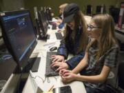 Ava Hanna of Battle Ground, 11, left, and Grace Maruhn of Vancouver, 11, search for music on a site called EarSketch during their second Girls Who Code session at the Vancouver Community Library on Wednesday evening. Girls Who Code is a national program aimed at closing the gender gap in technology, and getting more young woman involved in computer science.