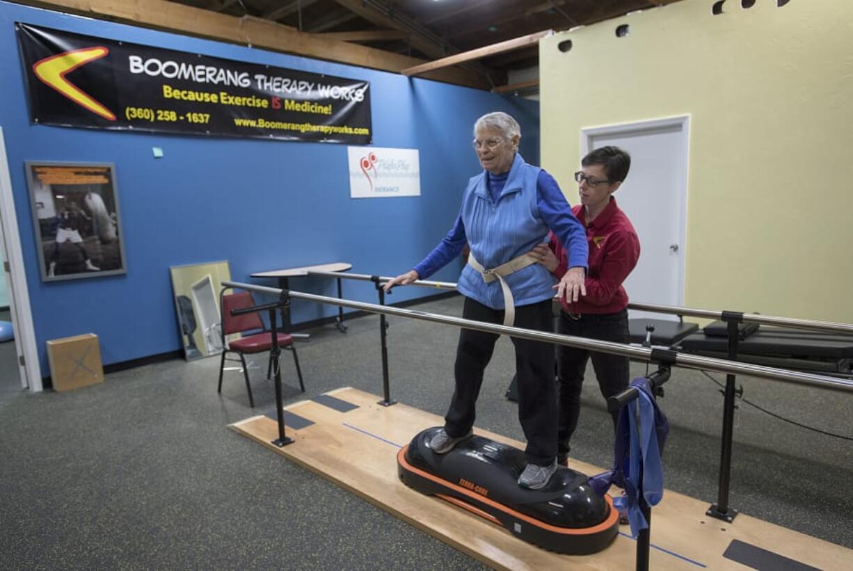 Physical therapist JJ Flentke helps patient Cathy Monbrod of Vancouver to balance during an exercise Tuesday morning at Boomerang Therapy Works in Vancouver. Flentke opened the gym, which focuses on keeping seniors active, in June.