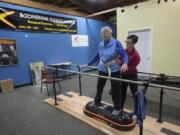 Physical therapist JJ Flentke helps patient Cathy Monbrod of Vancouver to balance during an exercise Tuesday morning at Boomerang Therapy Works in Vancouver. Flentke opened the gym, which focuses on keeping seniors active, in June.