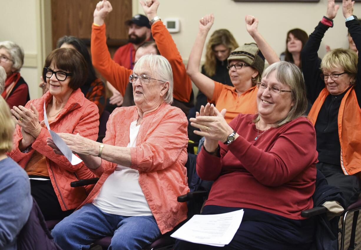 Lethene Parks, center, and Carrie Parks, right, applaud and cheer following the Port of Vancouver’s board of commissioners’ unanimous decision to put an end date on Vancouver Energy’s rolling lease for a proposed oil terminal, Tuesday January 9, 2018, at the Port of Vancouver.