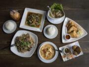 You’ll find a wide selection of dishes at Wild Tiger Thai restaurant in Vancouver, including, clockwise from bottom left, the noodles with beef, the stir-fried garlic with beef, the shrimp wonton soup, the Golden Triangle, the crispy egg rolls and the massaman curry.