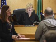 Defense attorney Lisa Toth, left, listens as Judge Kelli E. Osler, center, chats with a Mental Health Court participant Wednesday during a compliance review in Clark County District Court.