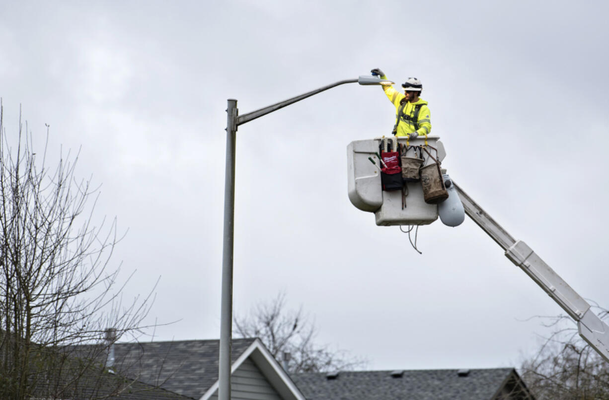 DJ’s Electrical lineman Rhett Lindberg of Winlock changes the current high-pressure sodium lights to new LED bulbs in Battle Ground.